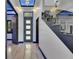 Modern home hallway featuring wood-look tile floors, glass staircase, and recessed lighting at 6528 Simone Shores Cir, Apollo Beach, FL 33572