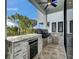 Outdoor kitchen with stainless steel appliances, stone accents, and a built-in grill, perfect for entertaining at 6528 Simone Shores Cir, Apollo Beach, FL 33572