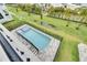 Aerial view of a rectangular pool with blue tile, surrounded by green grass and a fence at 6528 Simone Shores Cir, Apollo Beach, FL 33572