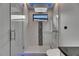 Sleek shower with tiled walls, rainfall showerhead, glass door, and small transom window at 6528 Simone Shores Cir, Apollo Beach, FL 33572
