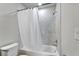 A clean bathroom featuring a shower-tub combination with a white shower curtain and tiled surround at 6658 Devlin Ln, Wesley Chapel, FL 33545