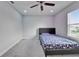 Bedroom with carpet flooring, a ceiling fan, and a bed with floral pattern bedding. A window provides natural light at 6658 Devlin Ln, Wesley Chapel, FL 33545