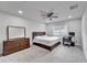 A well-lit bedroom featuring a large bed, ceiling fan, and carpeted floors at 6658 Devlin Ln, Wesley Chapel, FL 33545
