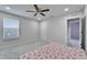 Bedroom with a light color palette, complemented by a modern ceiling fan and plush carpet at 6658 Devlin Ln, Wesley Chapel, FL 33545