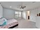 Cozy bedroom with ceiling fan, large windows with view of the backyard and decorated with twinkle lights at 6658 Devlin Ln, Wesley Chapel, FL 33545