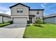 Charming two-story home with a well-manicured lawn, lush landscaping and attached two-car garage at 6658 Devlin Ln, Wesley Chapel, FL 33545