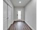 Bright foyer with dark wood flooring and white decorative glass front door at 6658 Devlin Ln, Wesley Chapel, FL 33545