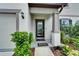 Charming front porch with a decorative glass door, lush landscaping, and welcome mat at 6658 Devlin Ln, Wesley Chapel, FL 33545