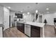 Spacious kitchen with stainless appliances, large island, dark cabinets and modern lighting at 6658 Devlin Ln, Wesley Chapel, FL 33545