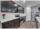 Modern kitchen featuring stainless appliances, stylish backsplash, and dark wood cabinets at 6658 Devlin Ln, Wesley Chapel, FL 33545