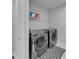 Bright laundry room with new side-by-side washer and dryer and overhead storage shelf at 6658 Devlin Ln, Wesley Chapel, FL 33545
