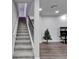 An interior of the living room showing the staircase and hard wood floors with a small tree at 6658 Devlin Ln, Wesley Chapel, FL 33545