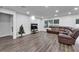 Spacious living room featuring wood flooring, recessed lighting, and a comfortable brown leather sectional at 6658 Devlin Ln, Wesley Chapel, FL 33545