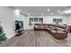 Large living room featuring hard floors, recessed lighting, and a plush leather sectional couch at 6658 Devlin Ln, Wesley Chapel, FL 33545