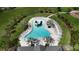 Aerial view of a community pool with a slide, palm trees, and plenty of lounge chairs at 6658 Devlin Ln, Wesley Chapel, FL 33545
