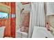 Cozy bathroom with a shower-tub combination, wood trim, and tiled walls at 675 64Th S Ave, St Petersburg, FL 33705