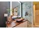 Stylish bathroom with illuminated mirror, wood countertop, and tropical-themed wallpaper at 675 64Th S Ave, St Petersburg, FL 33705