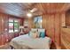 Bedroom with wood paneling, comfortable queen bed, and a peacock-themed decor at 675 64Th S Ave, St Petersburg, FL 33705