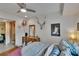 Bright bedroom with a ceiling fan, wood floors, eclectic decor, and ensuite bathroom access at 675 64Th S Ave, St Petersburg, FL 33705