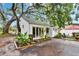 Beautiful home exterior with mature trees, lush landscaping, and a cozy outdoor space at 675 64Th S Ave, St Petersburg, FL 33705