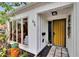 Close up of the front entrance showcasing the bright yellow front door, modern house numbers, and accent rocks at 675 64Th S Ave, St Petersburg, FL 33705