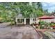 Charming single story home showcasing fresh white paint, verdant landscaping, and a inviting yellow front door at 675 64Th S Ave, St Petersburg, FL 33705