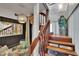 Wooden staircase next to a small seating area with a glass table and ornate decor at 675 64Th S Ave, St Petersburg, FL 33705