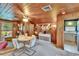 Well-lit living area with wood paneling, dining table, and easy access to the kitchen at 675 64Th S Ave, St Petersburg, FL 33705