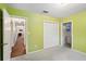 A light-green bedroom featuring double closets, neutral carpet, and a window at 6897 18Th N St, St Petersburg, FL 33702