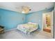 Calming bedroom featuring blue walls, floral bedding, and a decorative ceiling fan at 6897 18Th N St, St Petersburg, FL 33702