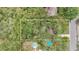 Aerial view highlighting the property, including the backyard pools and driveway, bordered with mature trees at 715 W 109Th Ave, Tampa, FL 33612