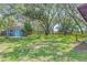 Expansive backyard featuring lush greenery, mature trees, and a charming shed at 715 W 109Th Ave, Tampa, FL 33612