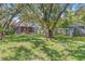 Expansive backyard with lush green grass, mature trees, a screened porch, and a shed at 715 W 109Th Ave, Tampa, FL 33612
