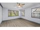 Bright bedroom with wood floors and two large windows overlooking the backyard at 715 W 109Th Ave, Tampa, FL 33612