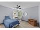 Serene bedroom with wood floors, ceiling fan, and views of nature from the bright window at 715 W 109Th Ave, Tampa, FL 33612