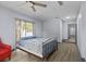 Comfortable bedroom featuring wood floors, ceiling fan, bright windows and charming red chair at 715 W 109Th Ave, Tampa, FL 33612