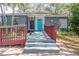 Charming home featuring a red railing, an accessible ramp, and a bright blue front door at 715 W 109Th Ave, Tampa, FL 33612