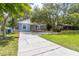 Inviting one-story home with well-maintained lawn, mature trees, and accessible ramp leading to the entrance at 715 W 109Th Ave, Tampa, FL 33612