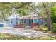 Charming single-story home with a lush landscaped yard, red railing, and a bright blue front door at 715 W 109Th Ave, Tampa, FL 33612