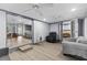 Bright living room with a large mirror, wood floors, and views to the kitchen and bedroom at 715 W 109Th Ave, Tampa, FL 33612