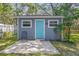 Exterior view of a charming shed with a concrete patio and a blue door at 715 W 109Th Ave, Tampa, FL 33612