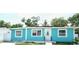 Charming turquoise single-story home featuring bright trim, updated windows, and solar panels at 7510 N Tampania Ave, Tampa, FL 33614