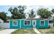 Charming turquoise single-story home featuring bright trim, updated windows, and solar panels at 7510 N Tampania Ave, Tampa, FL 33614