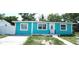 Turquoise single-story home with white trim, updated windows and lawn at 7510 N Tampania Ave, Tampa, FL 33614