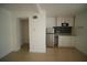 Efficient kitchen featuring stainless steel refrigerator, light cabinets, and neutral backsplash at 7510 N Tampania Ave, Tampa, FL 33614