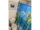 Toilet area with a themed shower curtain and a crab wall decoration at 800 Bayway Blvd # 14, Clearwater Beach, FL 33767