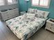 Bright bedroom with a tropical themed bedspread and white wicker furniture at 800 Bayway Blvd # 14, Clearwater Beach, FL 33767