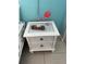 Close up of a white wicker nightstand decorated with a flamingo and beachy accents at 800 Bayway Blvd # 14, Clearwater Beach, FL 33767