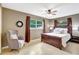 Relaxing bedroom with a wooden bed frame, a cozy chair, and ample natural light from two windows at 821 52Nd S Ave, St Petersburg, FL 33705