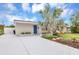 Inviting single-story home with a new driveway, desert landscaping, and a vibrant blue front door at 821 52Nd S Ave, St Petersburg, FL 33705